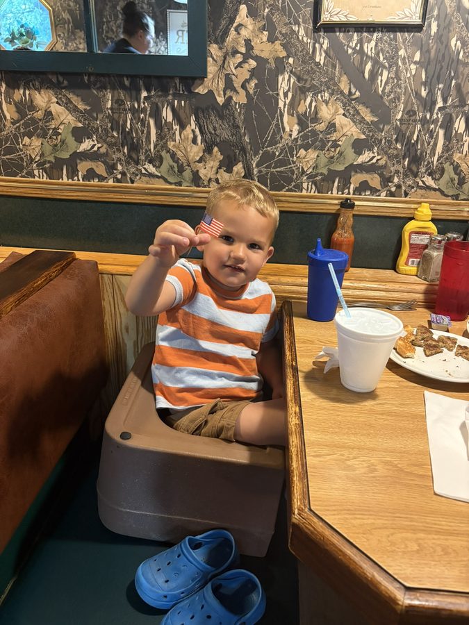 A young guest enjoying breakfast in a booth at J & L Breakfast House