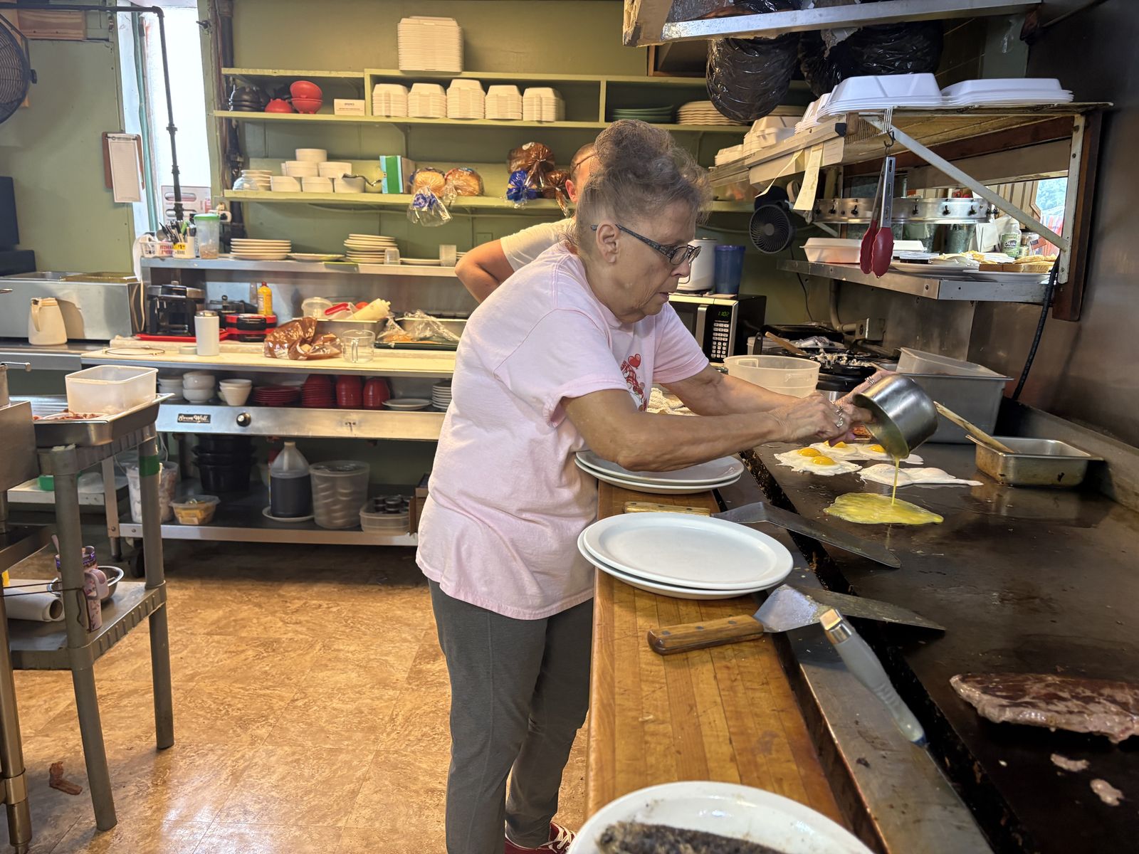 Eggs being poured onto the griddle in the kitchen