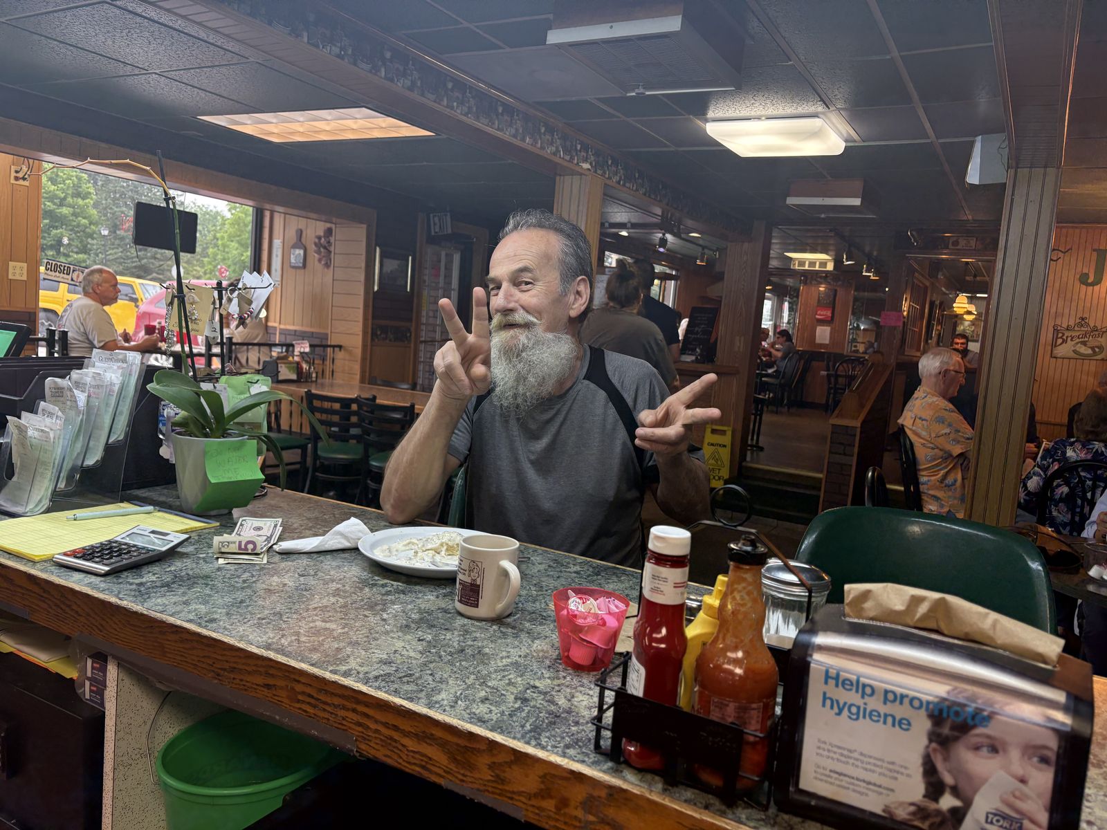 A regular at the counter flashing two peace signs