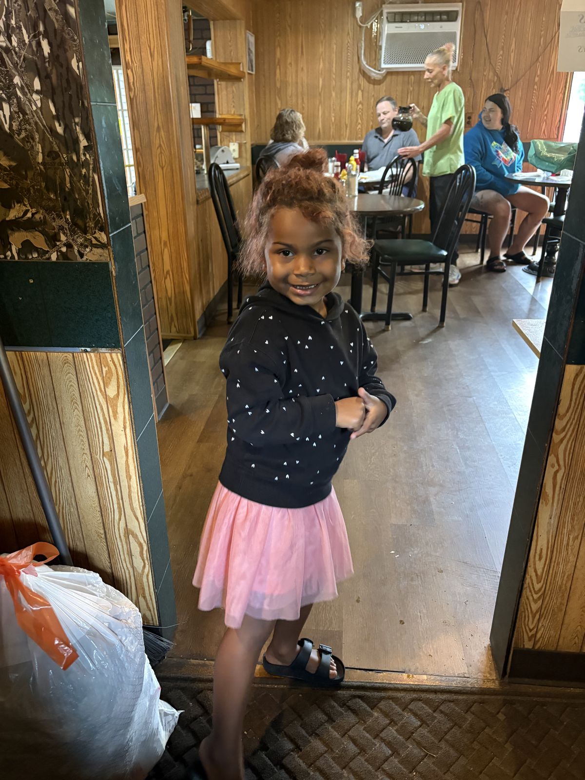 A young guest in a pink tutu smiling for the camera