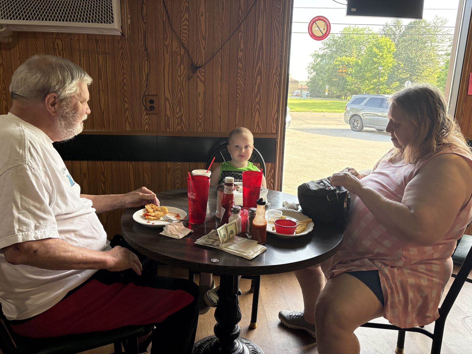 A family finishing breakfast at a table by the front window