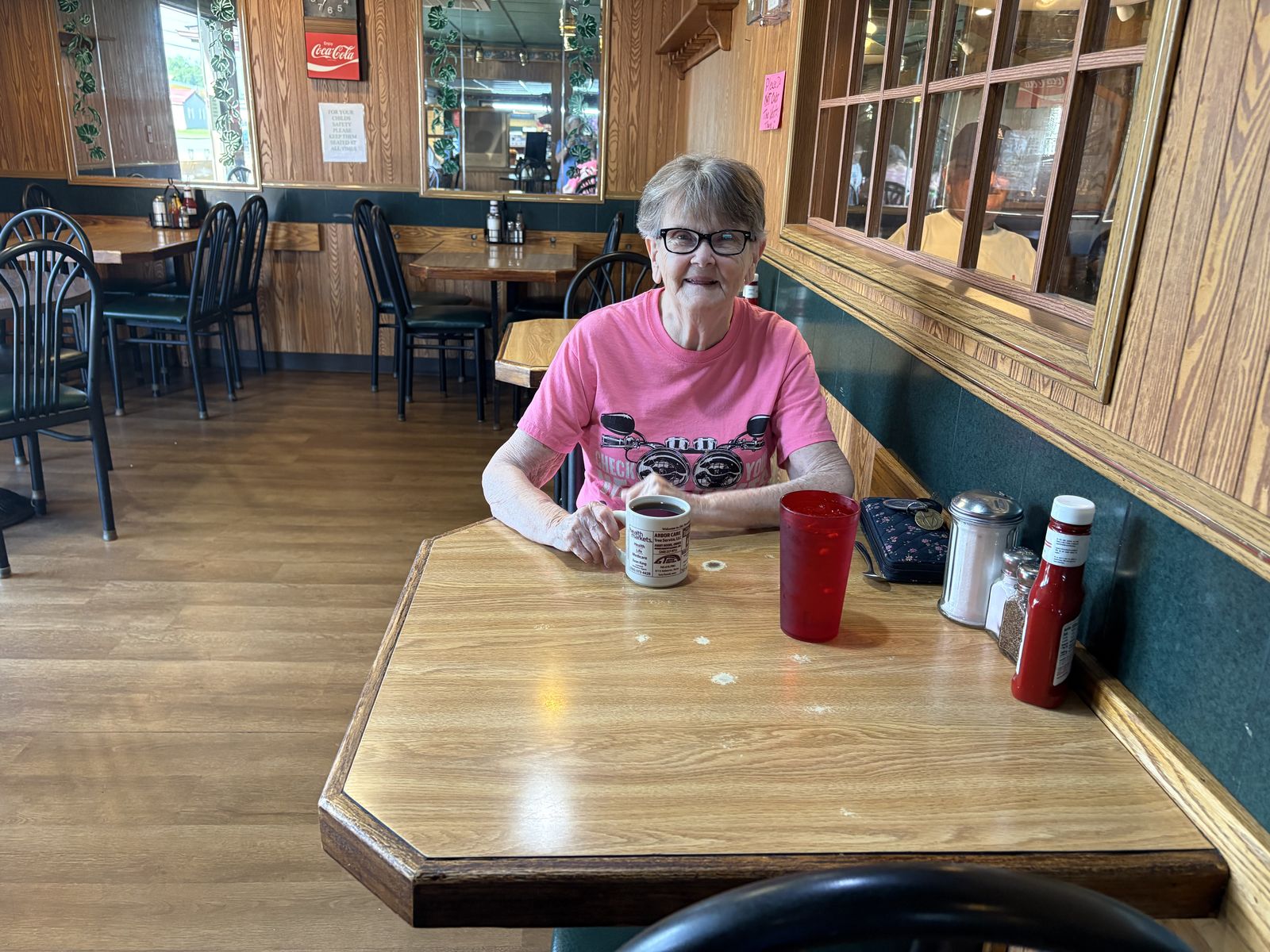 A guest smiling over a cup of coffee
