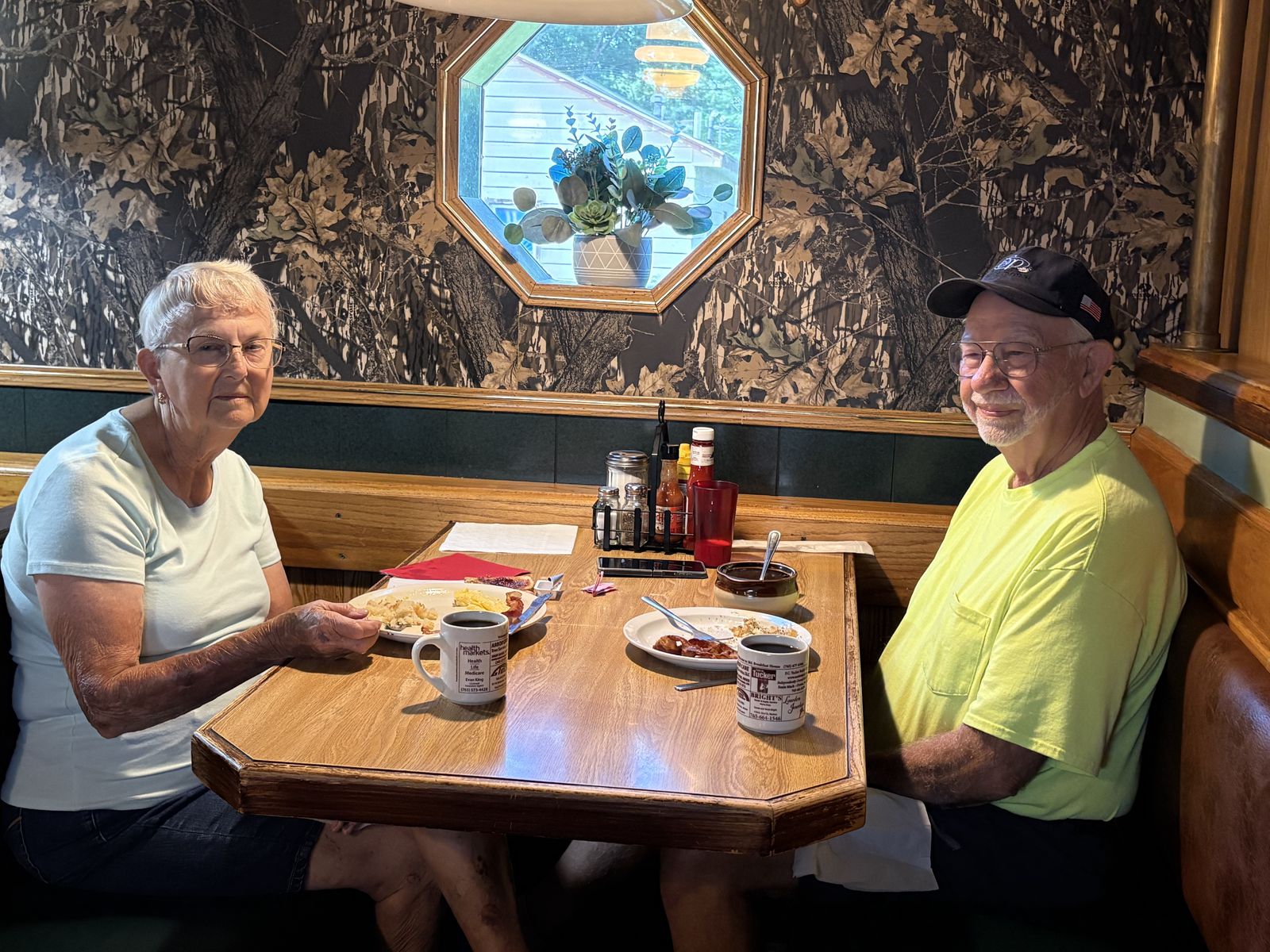 A couple enjoying breakfast together in a corner booth