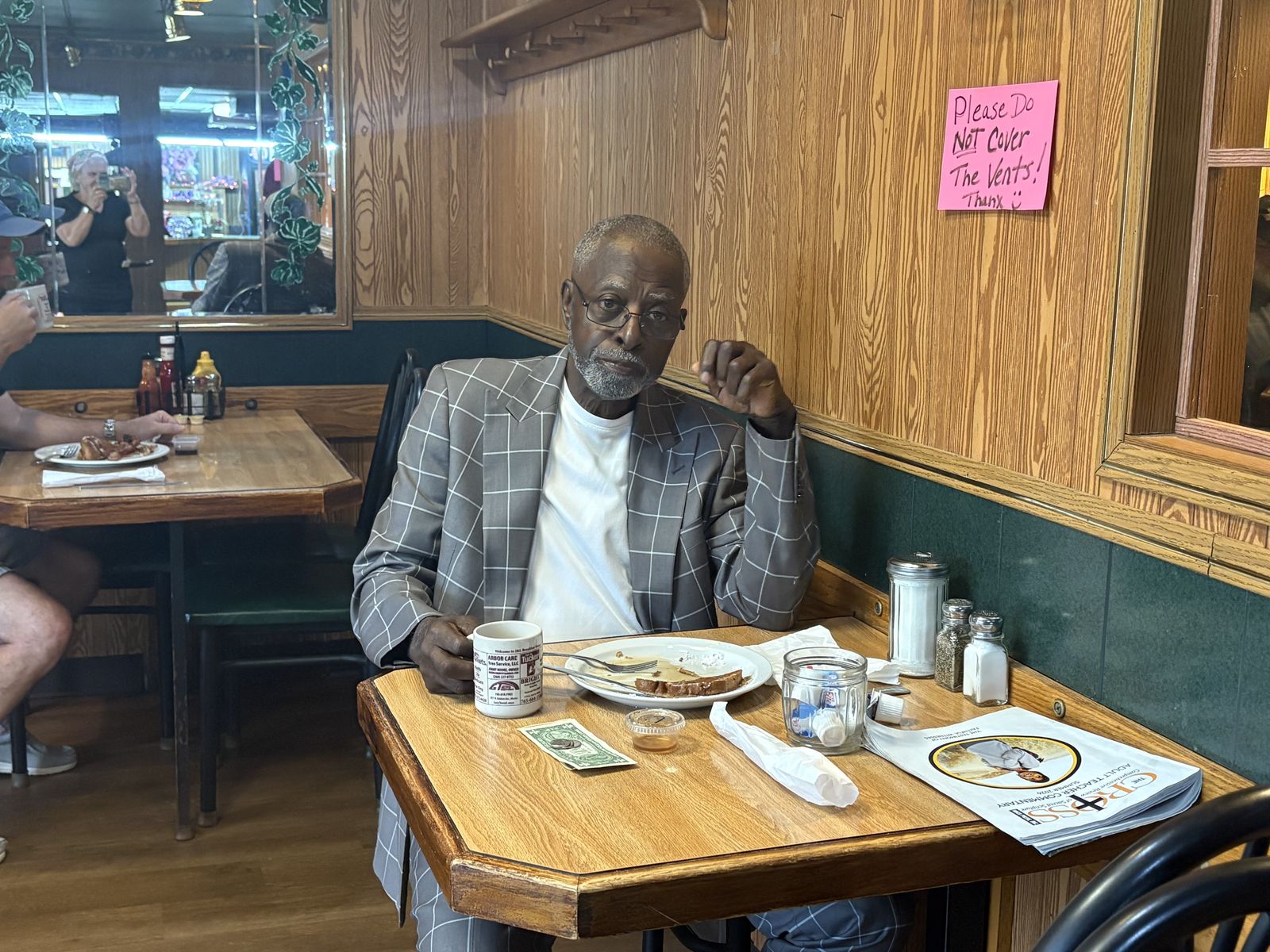 A sharply dressed regular finishing his coffee